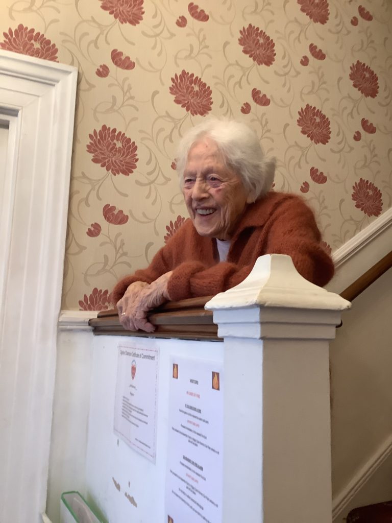 elderly woman leaning over bannister - our Care Home Gatwick article for Hilgay Care Home