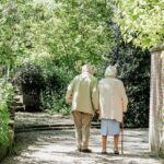 elderly couple walking among trees