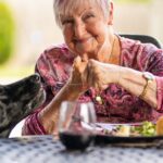 woman feeding food to a black labrador