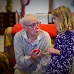 grandfather holding phone with granddaughter