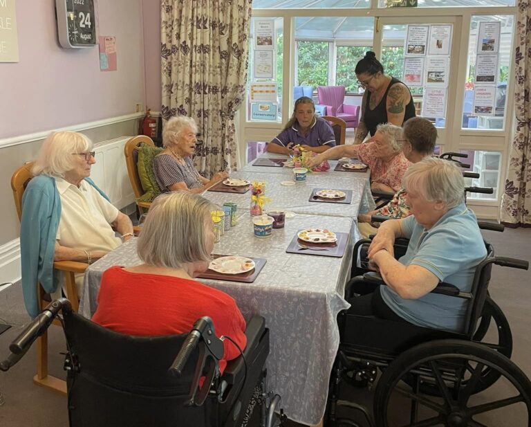 care home residents gathered around a table together