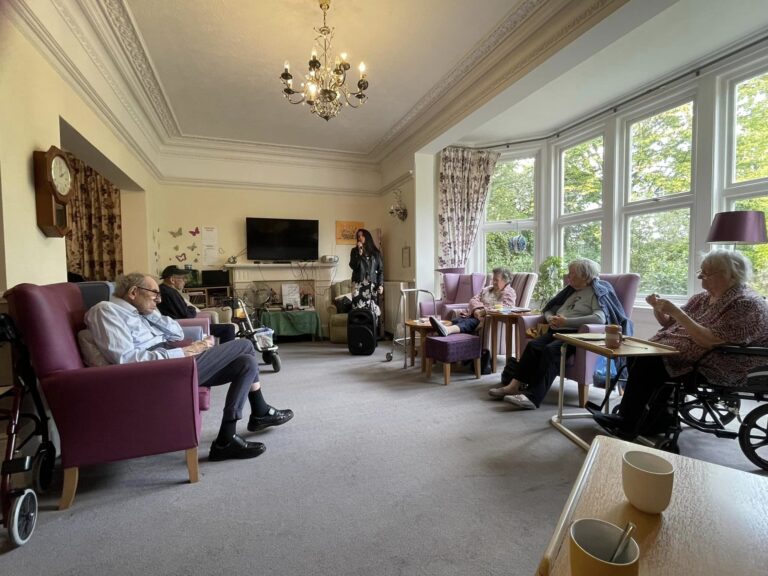 care home residents gathering and listening to music