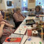 elderly women gathered around a table
