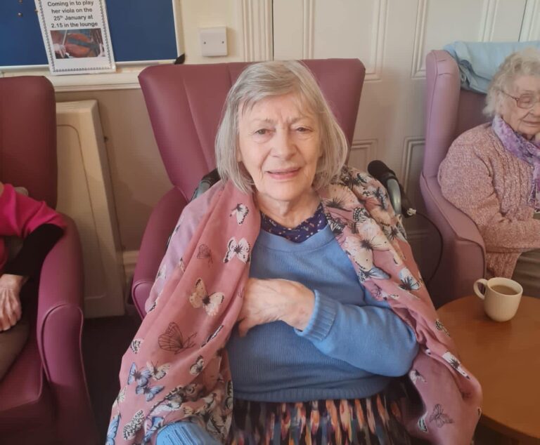 elderly woman in blanket smiling