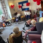 Rebecca from Borccoli and Biceps leading armchair exercises in a care home