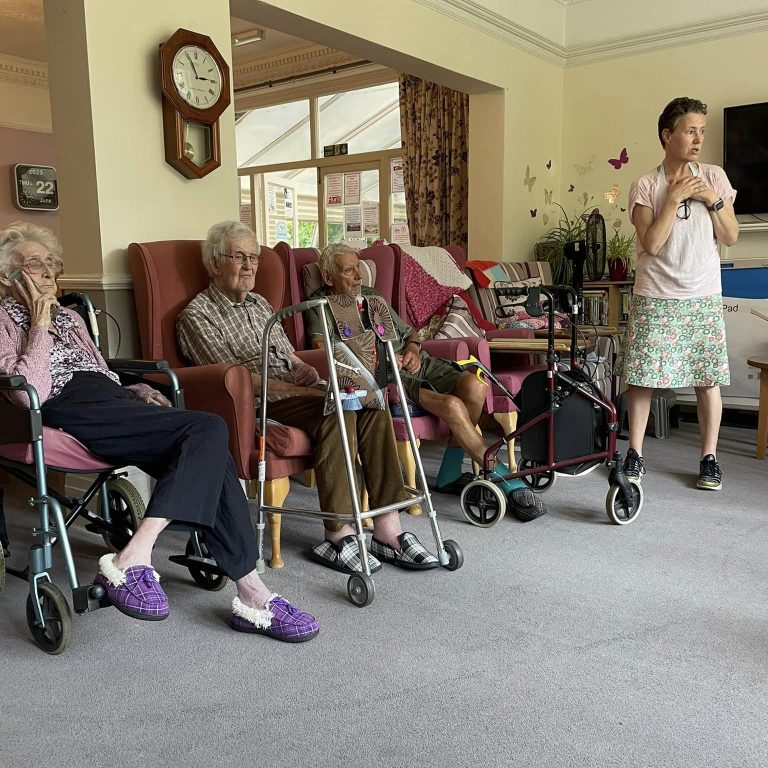 Author Patricia Rykiel discussing 'Don't Break My Rice Bowl' with residents at Hilgay Residential Care Home.