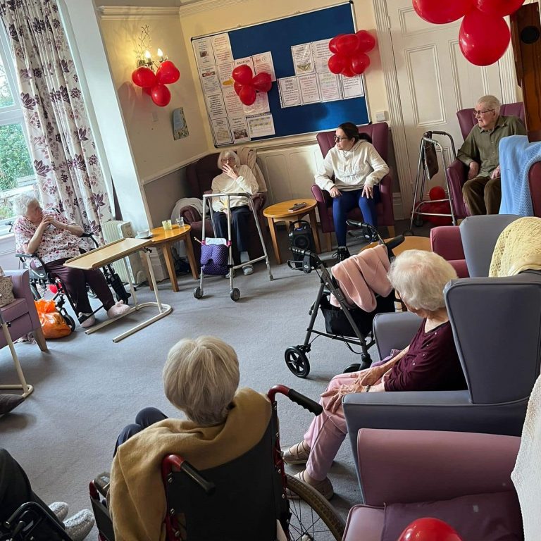Rebecca from Borccoli and Biceps leading armchair exercises in a care home
