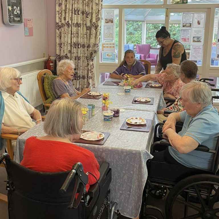 care home residents gathered around a table together