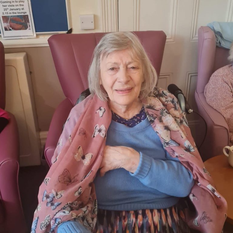 elderly woman in blanket smiling