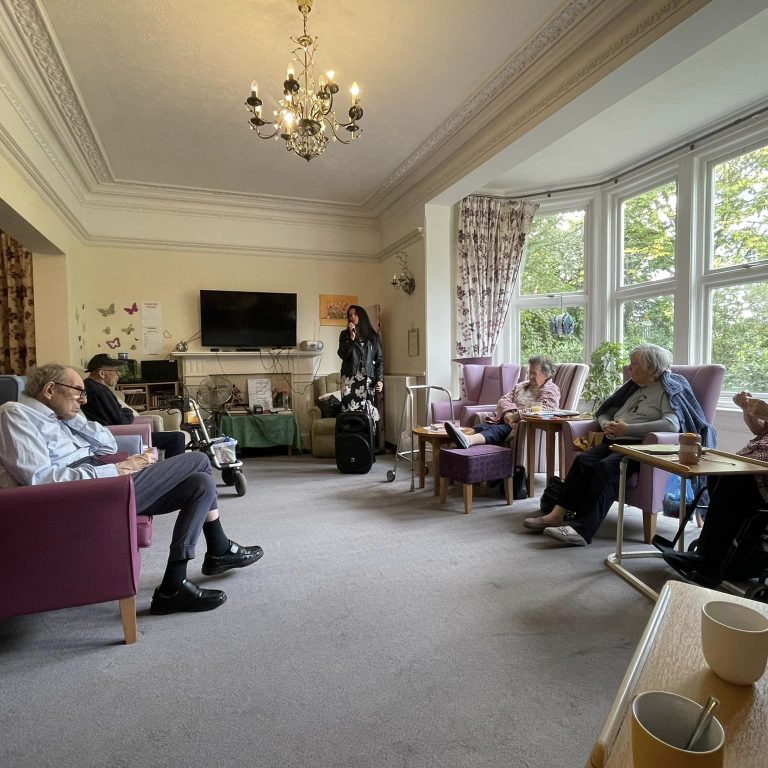 care home residents gathering and listening to music