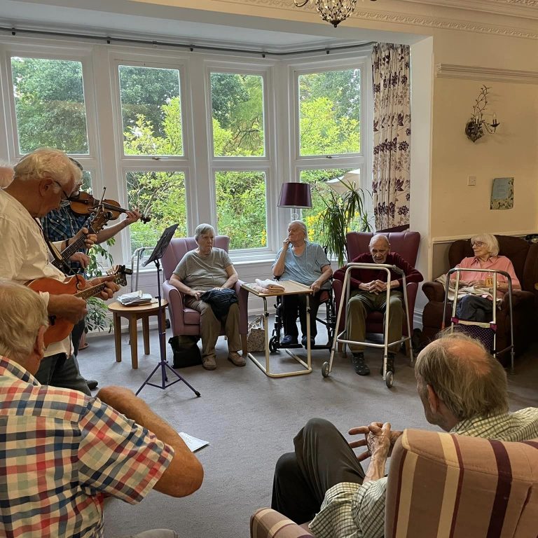 care home residents gathering around listening to music